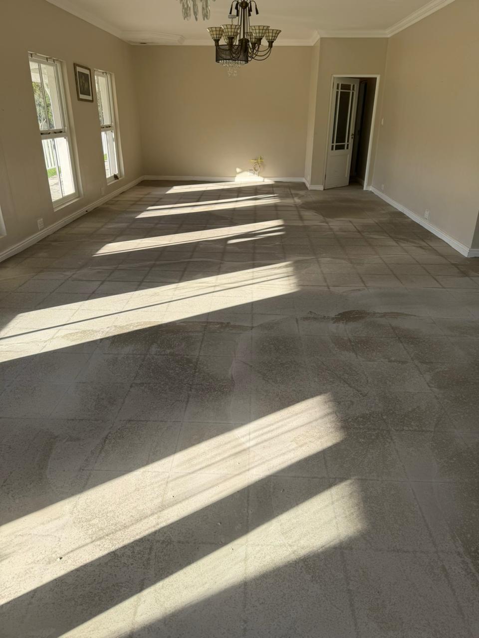 Finished interior room with tile flooring, painted walls, windows, and chandelier fixture.
