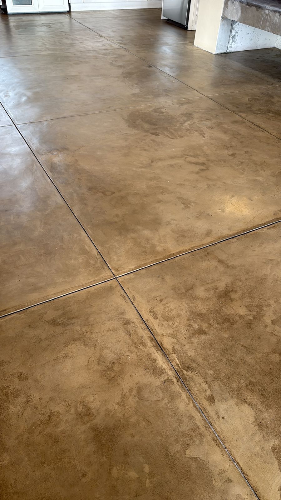 Polished concrete floor with control joints in residential space under construction.
