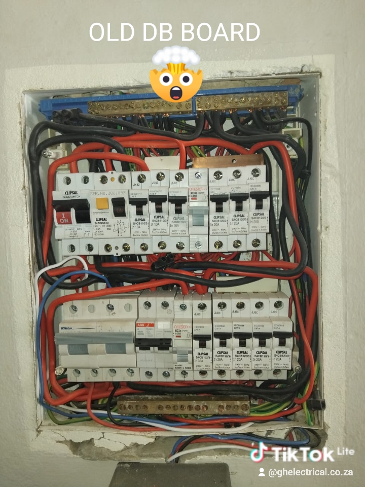 Aged electrical distribution board with CLIPSAL breakers, red wiring, and brass components requiring upgrade.
