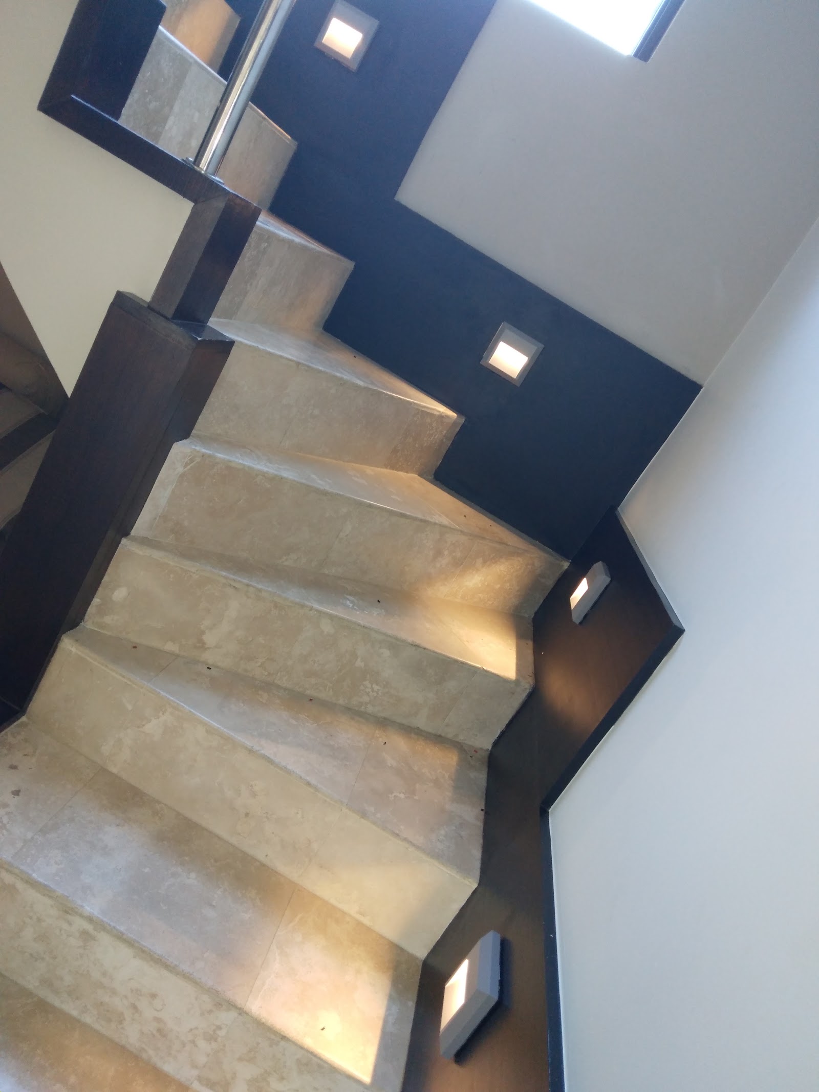 Interior staircase with dark blue walls and recessed lighting in residential space.