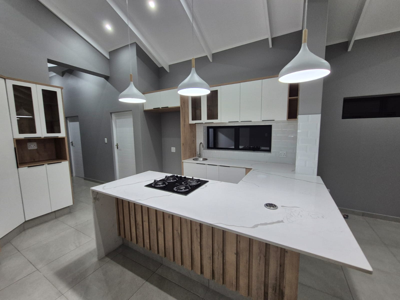 Interior kitchen rendering with modern appliances, white cabinetry, pendant lighting, and open-plan design.