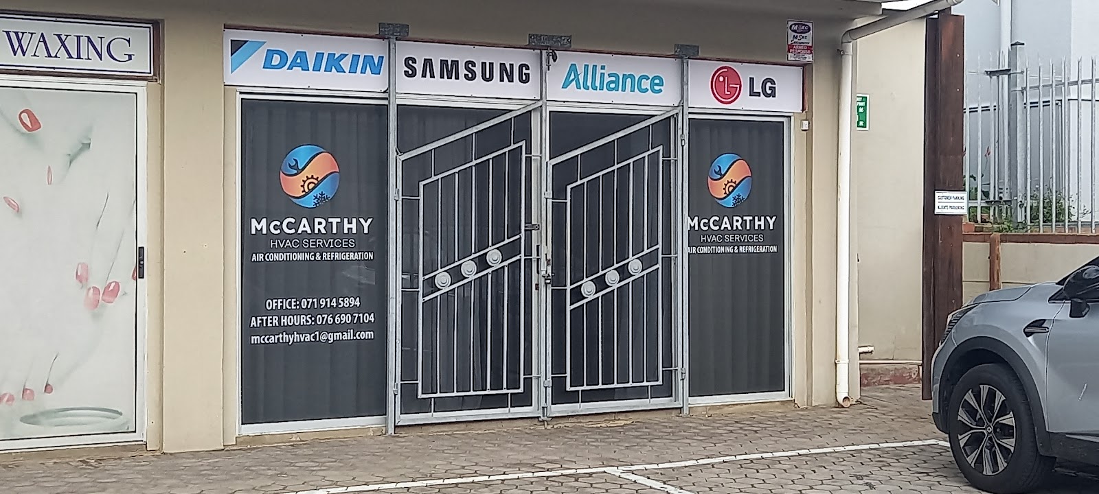McCarthy HVAC Services storefront with Samsung, Daikin, Alliance, LG brand signage and metal security gates.