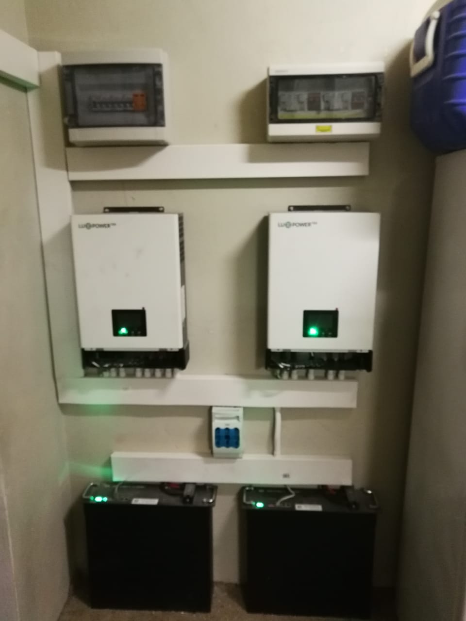 Two LV Power branded inverters with monitoring displays and battery storage units mounted indoors.