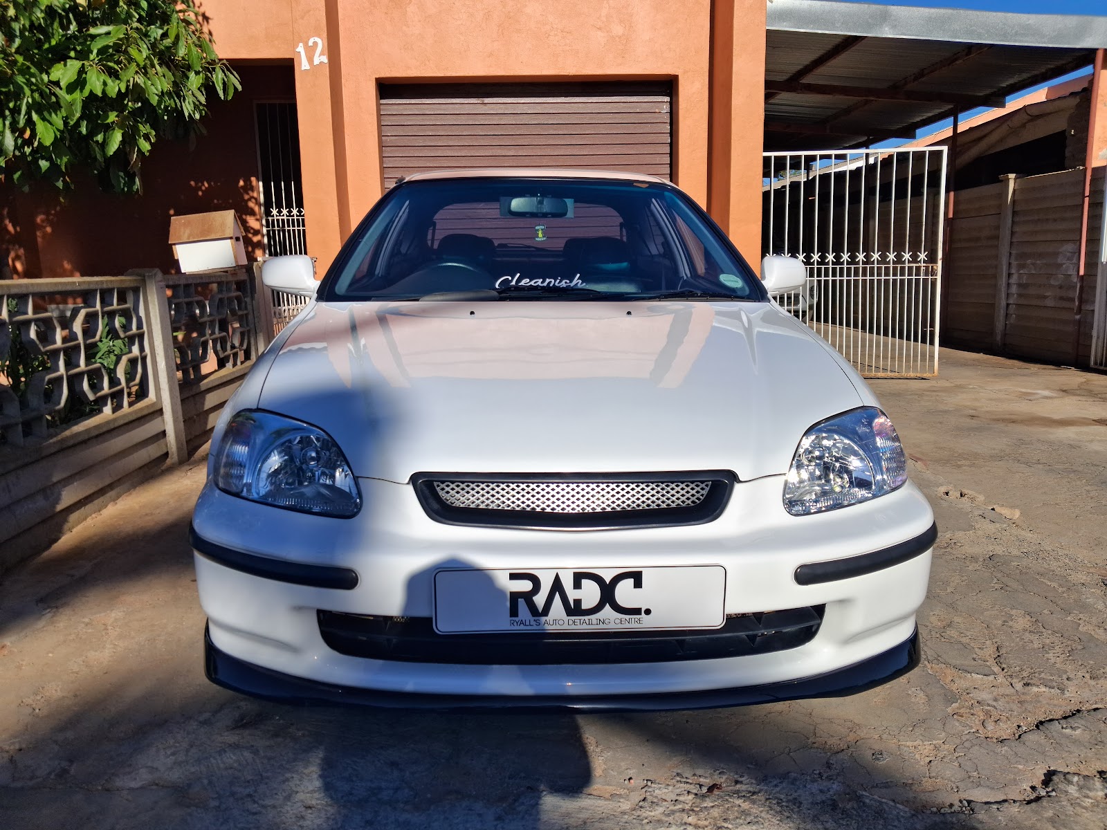 White vehicle with "Cleanich" windshield decal and "RADC" branding at location 12.