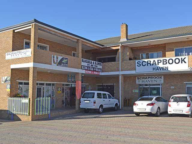 Scrapbook Haven brick building exterior with parking area, clear storefront signage, multiple vehicle spaces.