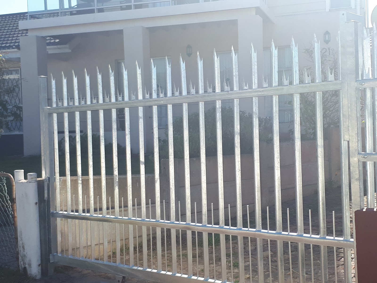 White palisade fence with pointed pickets installed on residential property.